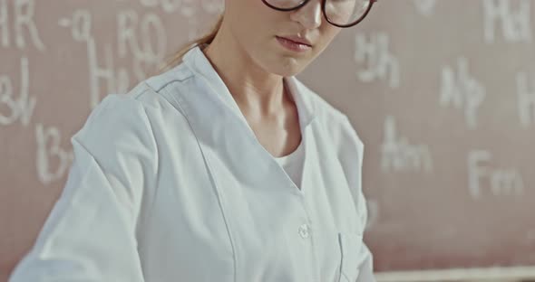 Camera Tilting Down To Hands of Young Woman Opening Bottle and Pouring Liquid Into Flask While alt