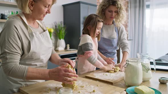 Video of three generations of women kneading dough in kitchen, Shot with RED helium camera in 8K