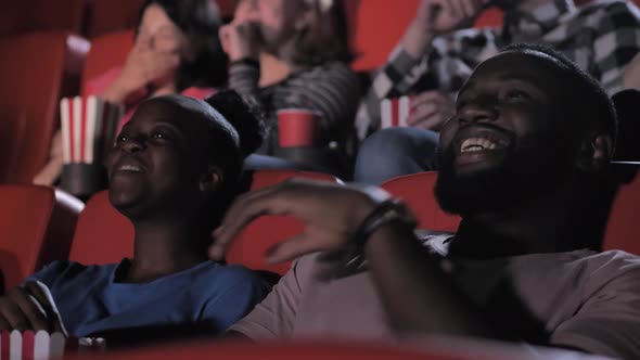 African American Couple Enjoying Comedy in Cinema
