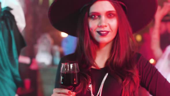 Attractive Woman with a Beautiful Smile Disguised As Witch at a Halloween Party
