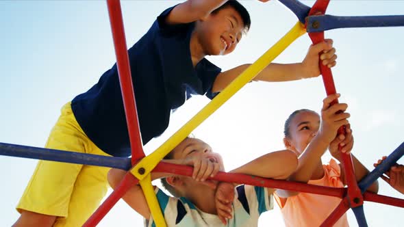 Schoolkids playing on dome climber in playground