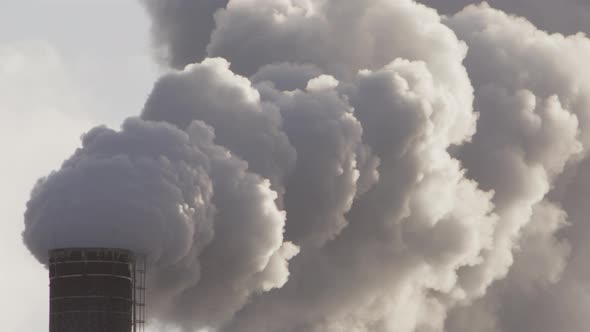 EPIC ZOOM OUT to thick billowing smoke from an industrial chimney