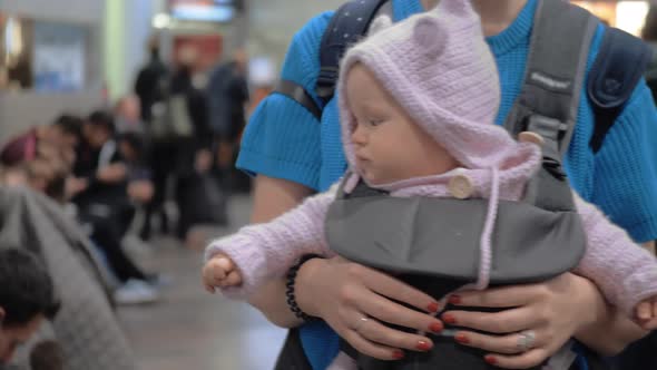 Cute Baby Girl in a Baby Carrier at Airport