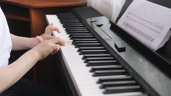 Electronic Piano. Children's Hands on a Keyboard Instrument. Side View.