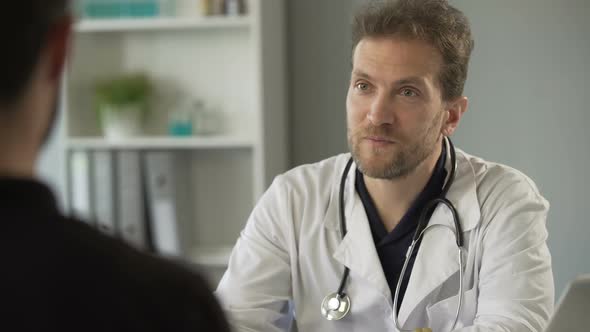 Male Therapist Chatting With Patient at Hospital, Healthcare and Medicine