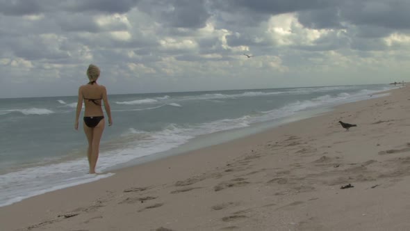 Female walking down a beach on her own