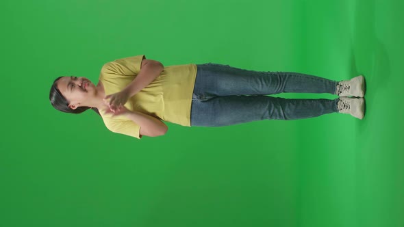 Asian Kid Girl And Emotionally Flipping Something While Clapping Hands In The Green Screen Studio