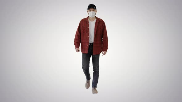 Man in Casual Shirt and Cap Walking in Medical Mask on Gradient Background.