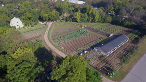 AERIAL: 360 Ascending view of a working vegetable farm in Austin, Texas.