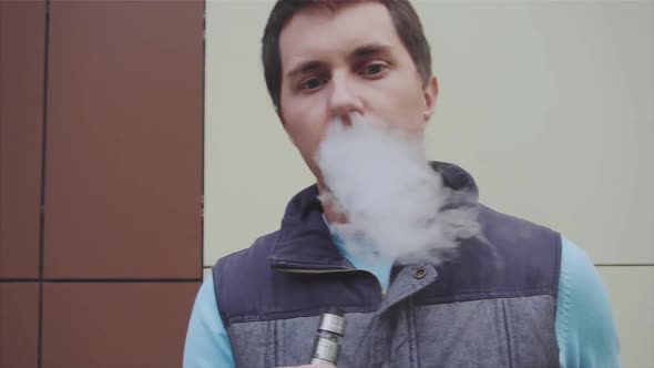 Young Vaper Man Exhaling Big Clouds of Smoke with Ecigarette Vape Slow Motion