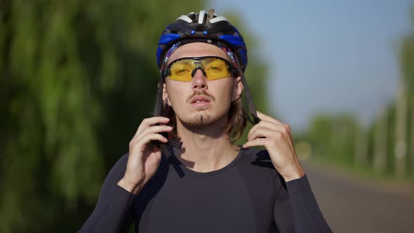 Sportsman Putting on His Helmet on a Bicycle Close Up