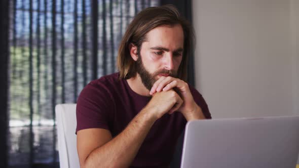 Caucasian man calculating finances and using laptop at home