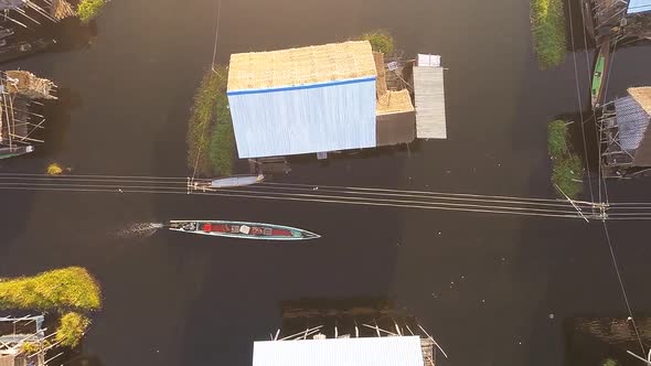 Canoe Running Trough the Channel with Traditional Wooden Houses and Other Vesels