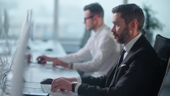 Portrait of Adult Entrepreneur in Open Space Office Working on Decktop Computer