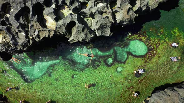 Young Beautiful Woman Swims in a Natural Pool Angel's Billabong at Broken Beach in Nusa Penida