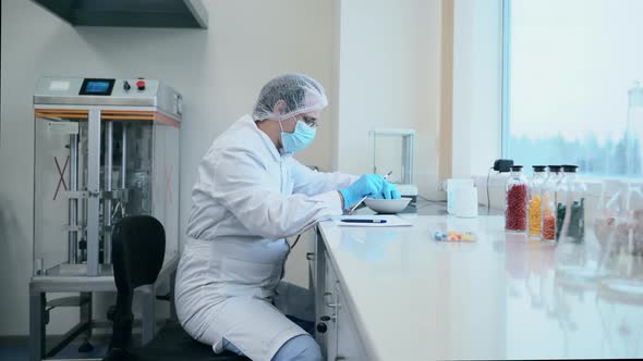 Doctor Scientist Sitting in Pharmaceutical Laboratory Doing Measurement of Tablet