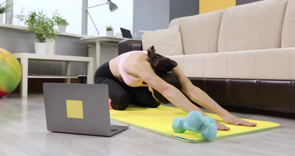 Young Woman Doing Gymnastic Exercises to Stretch Spine on Mat at Home