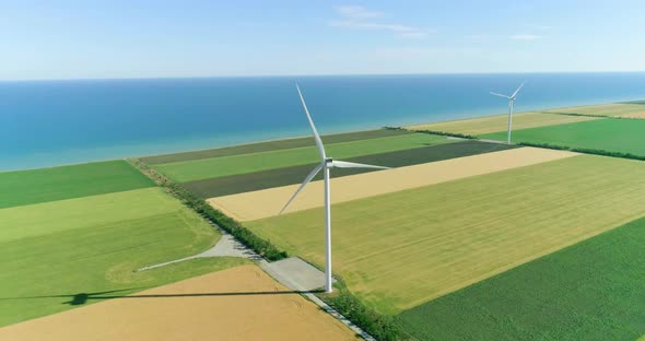 Group of windmills for electric power production in the agricultural fields. Aerial view.