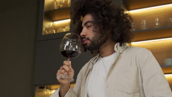 Egyptian Man Holds Glass of Red Wine Smelling Before Drink