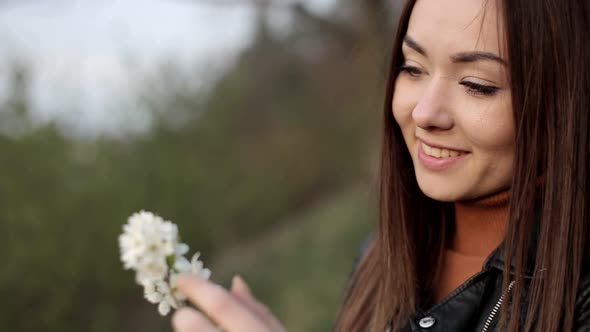 Beautiful Brunette with a White Flower in Her Hands