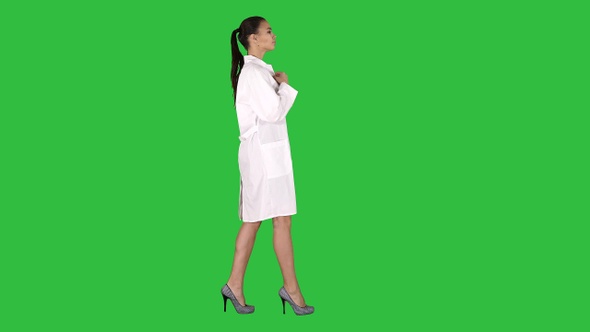 Young woman pharmacist in white gown coat uniform walking