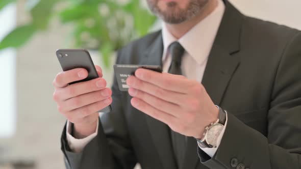 Close Up of Middle Aged Businessman Having Online Payment on Smartphone