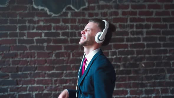 Handsome Business Man Dressed Business Suit Headphones Dancing Indoor Red Brick Wall Background