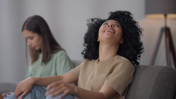 Cheerful Young Slim African American Woman Having Fun Tossing Hair Looking at Camera As Asian