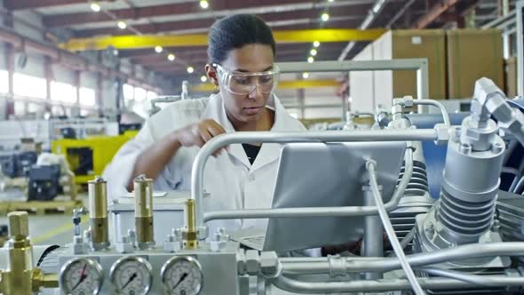 African Female Factory Engineer Using Laptop