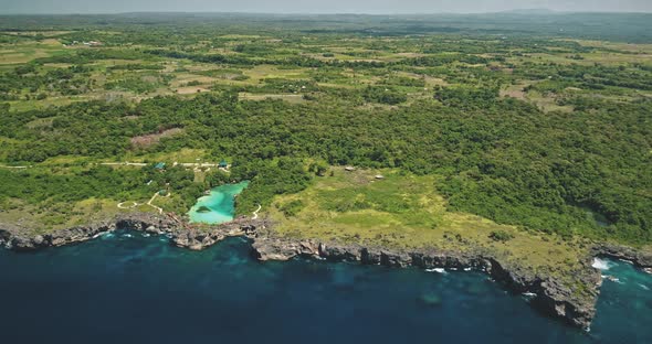 Green Tropic Forest at Cliff Sea Bay with Turquoise Salt Water Lake Aerial View