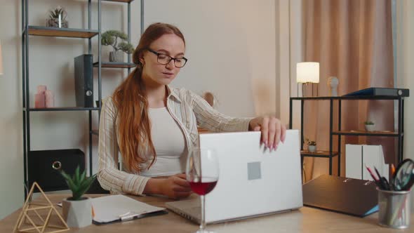 Woman Freelancer Drinking Wine From Glass After Online Distance Video Call on Laptop at Home Office