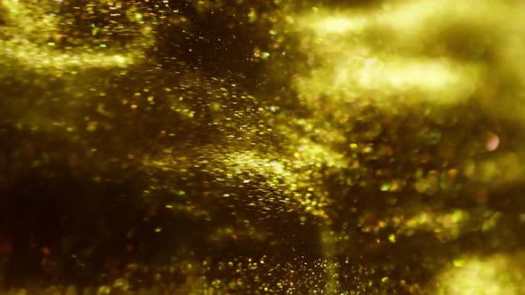 Golden Ink in Water Shooting with High Speed Camera. Gold Drops of Paint Dropped, Reacting, Creating