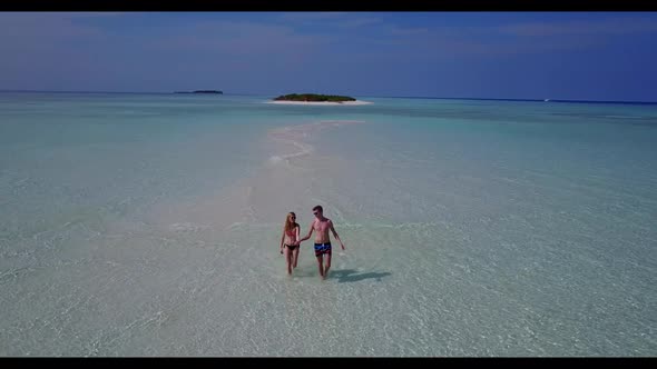 Two people suntan on tropical bay beach lifestyle by turquoise lagoon with white sandy background of
