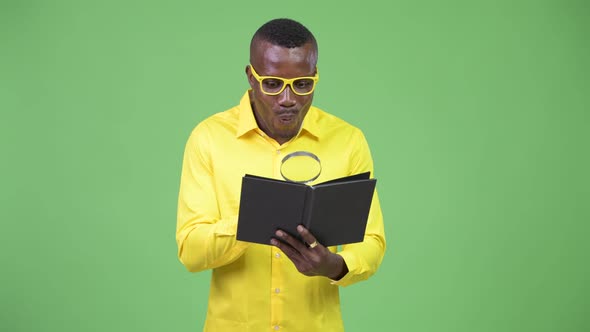 Young Happy African Nerd Businessman Reading Book