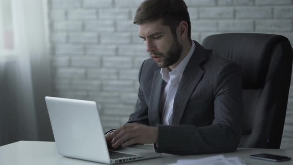Pensive Businessman Typing on Laptop, Nervous About Difficult Startup Solution