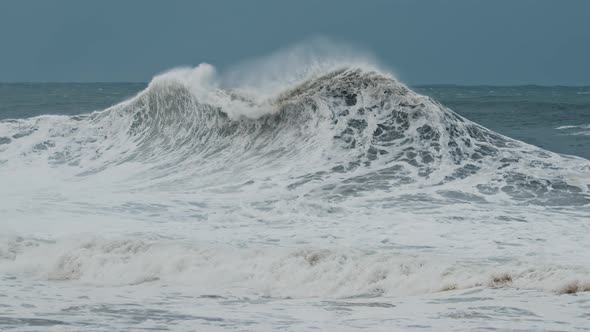 Big Wave with Foam and Dirt Breaks on the Shore During Strong Storm in the Atlantic Ocean