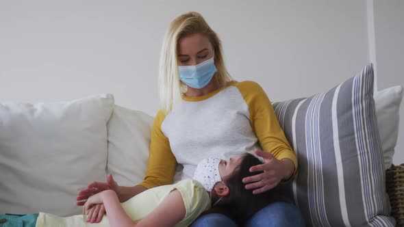 Mother and daughter wearing face masks playing with each other at home