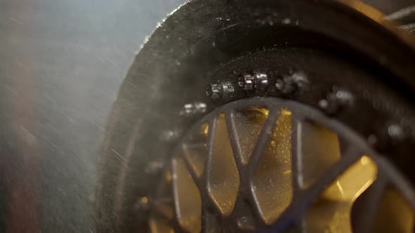 Water Falls on Beautiful Freshly Painted Rim From Car with Water Drops on Polished Shelves and Bolts