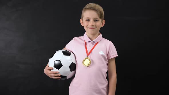 Boy With Ball and Medal Standing Near Blackboard, Football Competition Winner