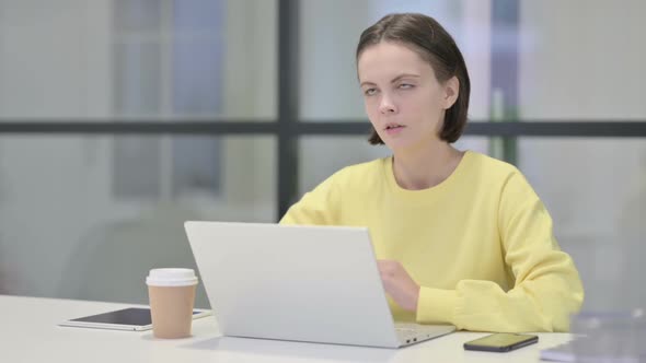 Young Woman Reacting to Loss While Using Laptop