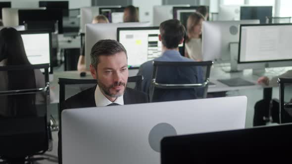 Portrait of Young Entrepreneur in Open Space Office Working on Decktop Computer