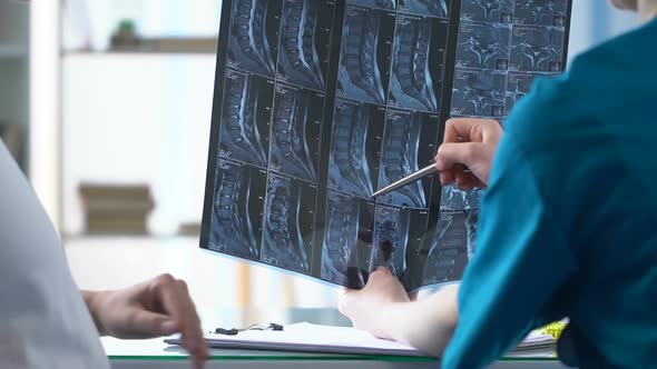 Pregnant Woman Listening to Doctor Showing Her Back X-Ray Result, Backpain