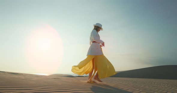 Woman in Desert . Girl Is Having Fun in Nature. Slow Motion Model in Dress