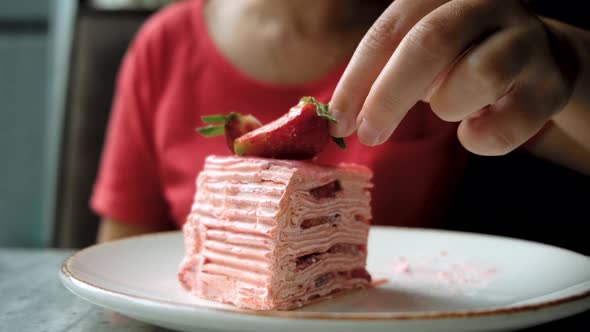 Girl Eats Strawberry Decoration on Strawberry Cake
