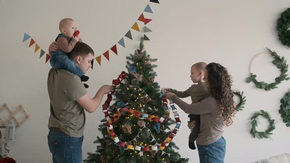 Big Family of Four Decorating Christmas Tree