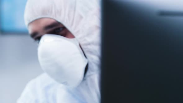 Dolly Revealing Shot of Biologist in White Coverall Analyzing a Plant Sample