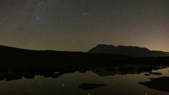Black Stones in Lake and Stars Moving in Dark Night Sky in Perseid Meteor Shower 2020 Ardabil Highla