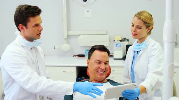 Dentists showing dental report on digital tablet
