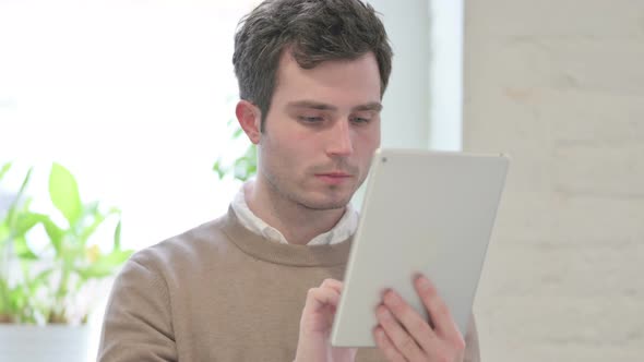 Portrait of Attractive Man Using Tablet in Office