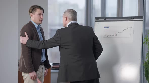 Portrait of Young Handsome Male Employee Talking with CEO in Office